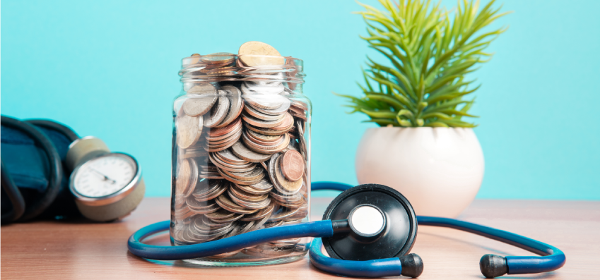 close up jar on table filled with coins against blue background